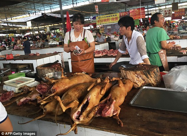 Vendors stand behind a pile of dog meat at the Nanqiao market in Yulin, China, today