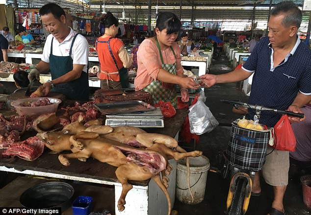 A vendor sells dog meat to a customer at the Nanqiao market as the festival begins today
