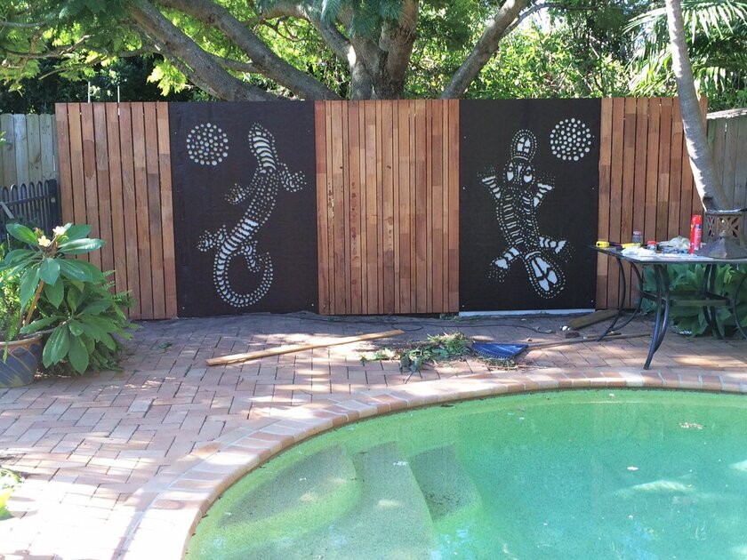 Decorative screens used as fence panels around a backyard pool ...