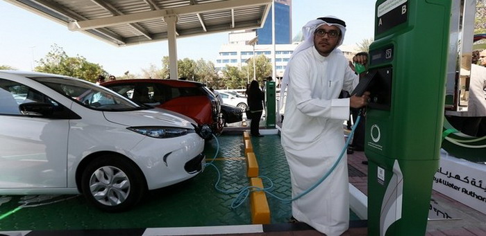 رجل اماراتي يشحن سيارته كهربائية