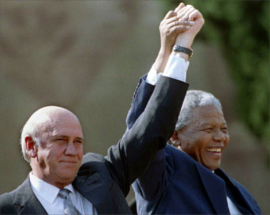 South African President Nelson Mandela (R) and Second Deputy President F.W. de Klerk hold their hands high as they address the people after the Inauguration ceremony in front of Union Building, Pretoria in this May 10, 1994 file photo.