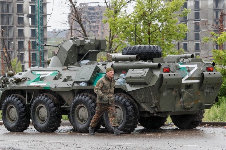 Service members of pro-Russian troops walk in Mariupol