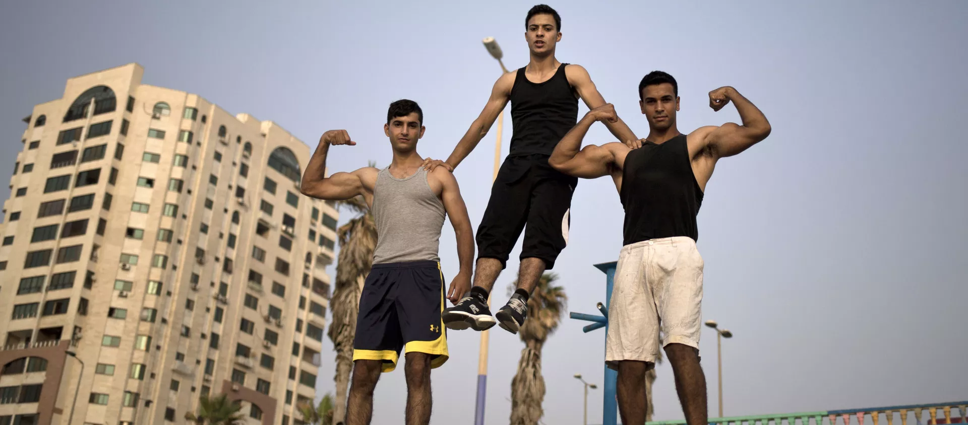 شباب غزة يعرضون عضلاتهم في أحد الشوارع بالقرب من شاطئ البحر  - سبوتنيك عربي, 1920, 07.12.2020