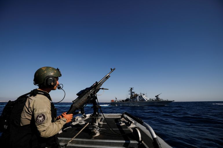 An Israeli soldier stands on her naval boat while patrolling the Mediterranean Sea off the southern Israeli coast as Israel-Gaza fighting rages on